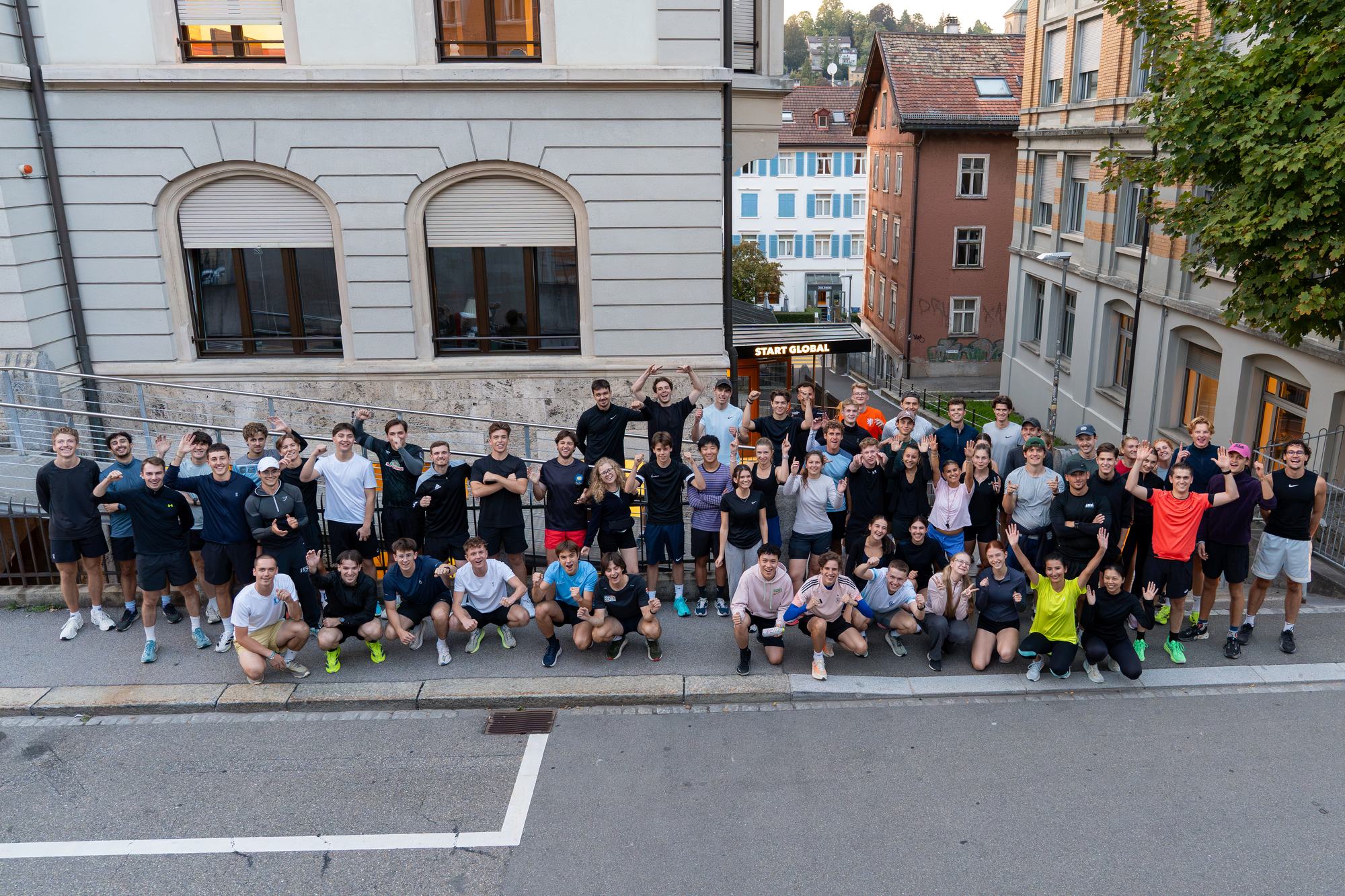Big group photo of Momentum runners waving on a street in St.Gallen