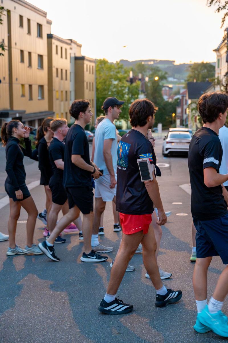 Momentum runners heading down a street in St.Gallen at dusk